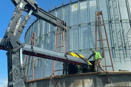 Installation of a sweep auger inside the grain silo
