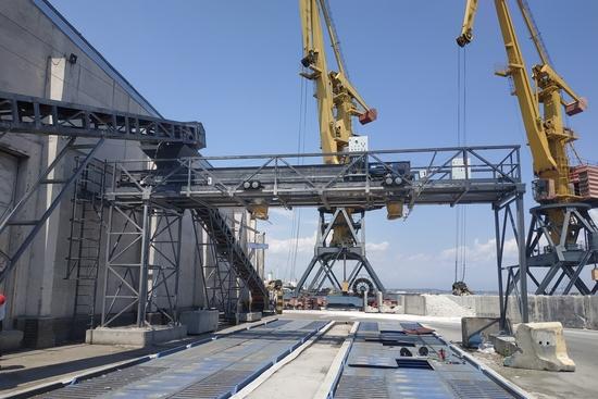 Система завантаження зерна з похилим конвеєром, що веде до горизонтальної естакади над автомобільними вагами