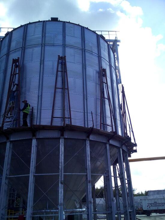 Installation of a steel hopper-bottom grain storage silo at a grain elevator facility